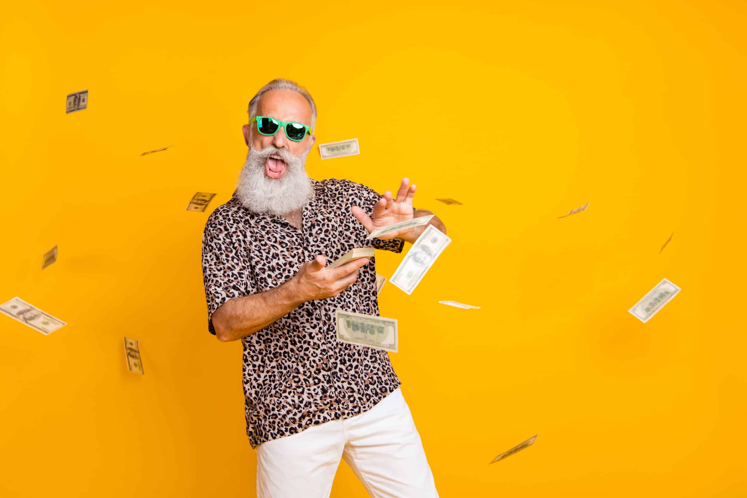  Ein Mann mit Bart, Sonnenbrille und Shirt im Leopardenmuster wirft mit Geldscheinen um sich.